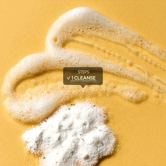A close-up texture shot showing a skincare product in both powder and foaming lather states on a yellow background.